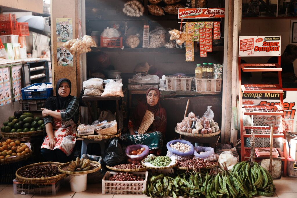 Two women selling vegetables and spices in Jogja market, Indonesia.