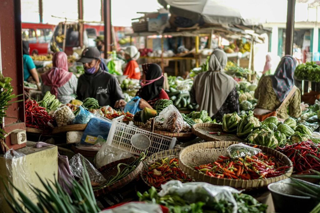 Bustling Asian marketplace with vendors selling fresh vegetables, creating a lively and colorful atmosphere.