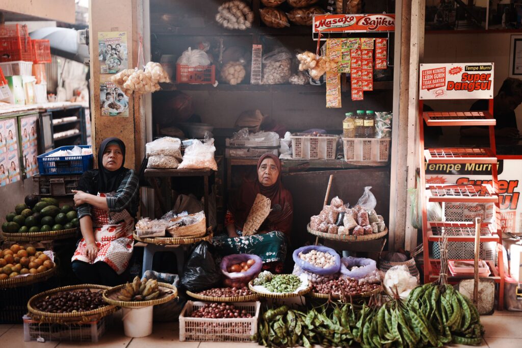 Two women selling vegetables and spices in Jogja market, Indonesia.